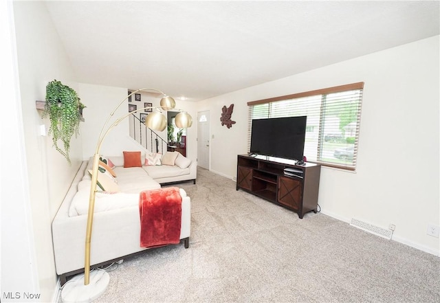 1087 Madrid Dr, Akron, OH 44313 - carpeted living area with stairs and baseboards