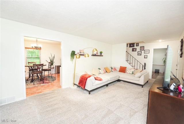 1087 Madrid Dr, Akron, OH 44313 - living room featuring carpet, stairs, a chandelier, and baseboards