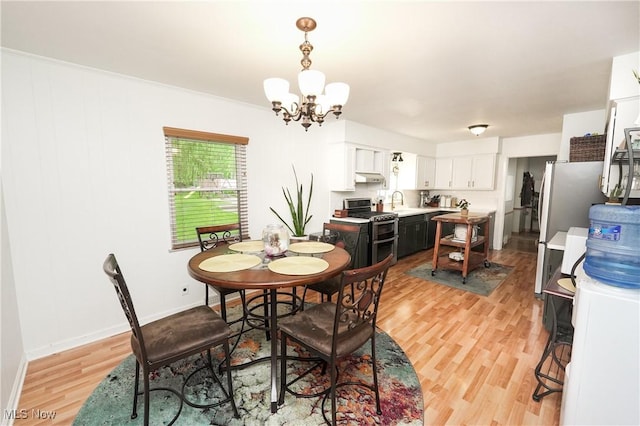 1087 Madrid Dr, Akron, OH 44313 - dining space with a chandelier, light wood-style floors, and baseboards