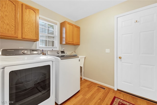 3527 Perry Ct, Lorain, OH 44053 - laundry area with washing machine and dryer, light wood-type flooring, cabinet space, and baseboards