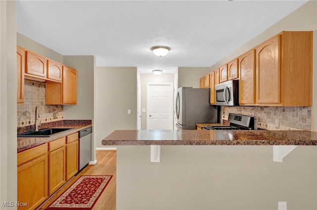 3527 Perry Ct, Lorain, OH 44053 - kitchen featuring stainless steel appliances, a sink, a peninsula, and backsplash