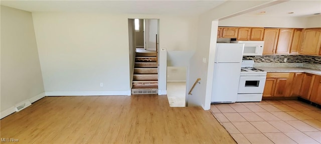 4321 W 181st St, Cleveland, OH 44135 - kitchen with white appliances, light wood-type flooring, light countertops, decorative backsplash, and baseboards