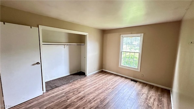 24 Washington Sq, Euclid, OH 44143 - unfurnished bedroom featuring wood finished floors, a closet, and baseboards