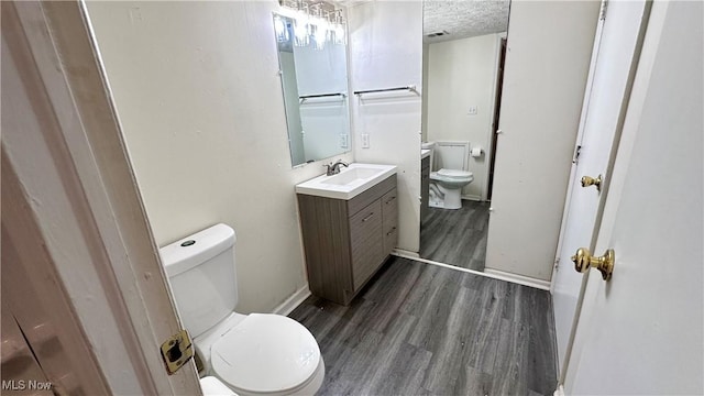 24 Washington Sq, Euclid, OH 44143 - half bathroom with toilet, wood finished floors, vanity, baseboards, and a textured ceiling
