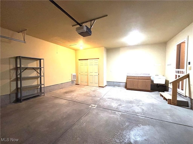39 Village Ct, Columbiana, OH 44408 - garage with a garage door opener, a sink, and baseboards