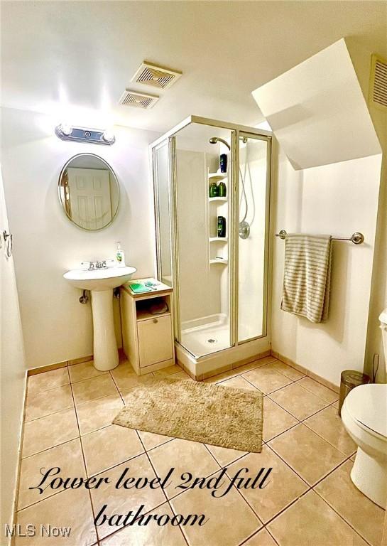 6101 Laurent Dr, Parma, OH 44129 - full bath featuring tile patterned flooring, a shower stall, toilet, and baseboards