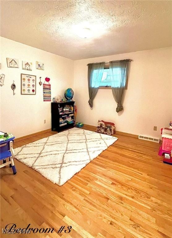 6101 Laurent Dr, Parma, OH 44129 - recreation room with wood finished floors and a textured ceiling