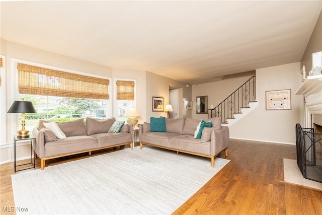 23935 Duffield Rd, Shaker Heights, OH 44122 - living room featuring wood finished floors, stairs, a fireplace with flush hearth, and baseboards