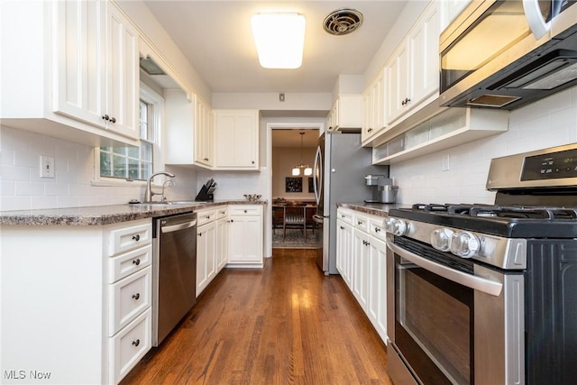 23935 Duffield Rd, Shaker Heights, OH 44122 - kitchen featuring stainless steel appliances, a sink, white cabinetry, dark wood-style floors, and decorative backsplash