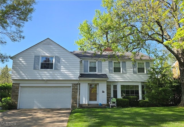 23935 Duffield Rd, Shaker Heights, OH 44122 - view of front facade featuring a garage, a front lawn, driveway, and stone siding