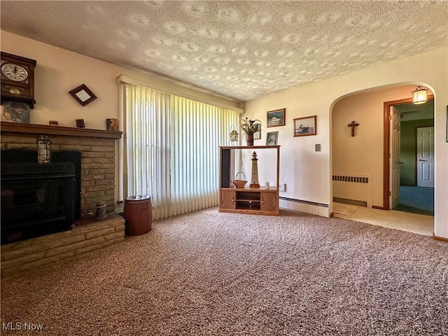 2308 Bears Den Rd, Youngstown, OH 44511 - carpeted living room with radiator, a textured ceiling, arched walkways, a stone fireplace, and baseboard heating
