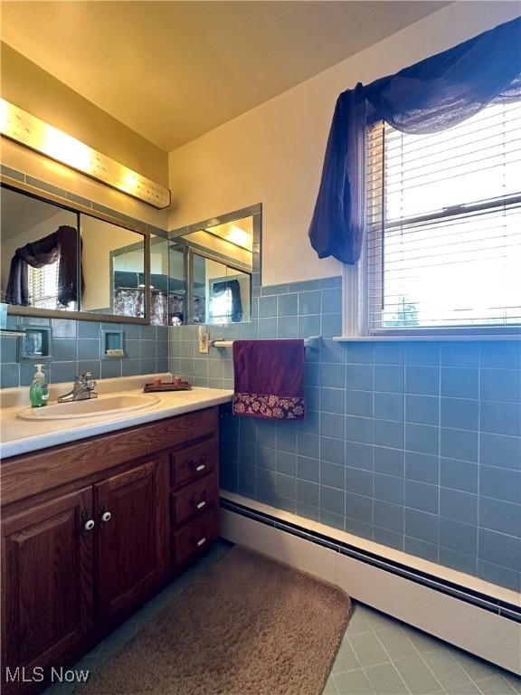 2308 Bears Den Rd, Youngstown, OH 44511 - bathroom with a baseboard radiator, tile walls, vanity, and tile patterned floors