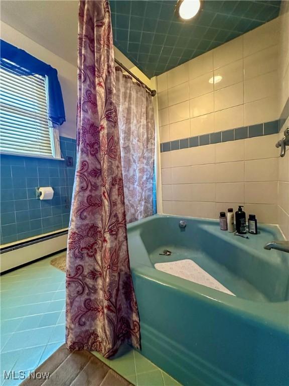 2308 Bears Den Rd, Youngstown, OH 44511 - bathroom with tile walls, baseboard heating, tile patterned floors, and shower / tub combo with curtain