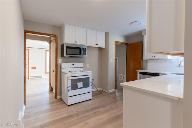 4827 E 88th St, Garfield Heights, OH 44125 - kitchen featuring appliances with stainless steel finishes, light wood finished floors, white cabinetry, and light stone countertops