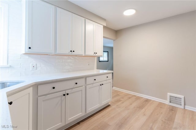 4827 E 88th St, Garfield Heights, OH 44125 - kitchen featuring decorative backsplash, baseboards, and white cabinetry
