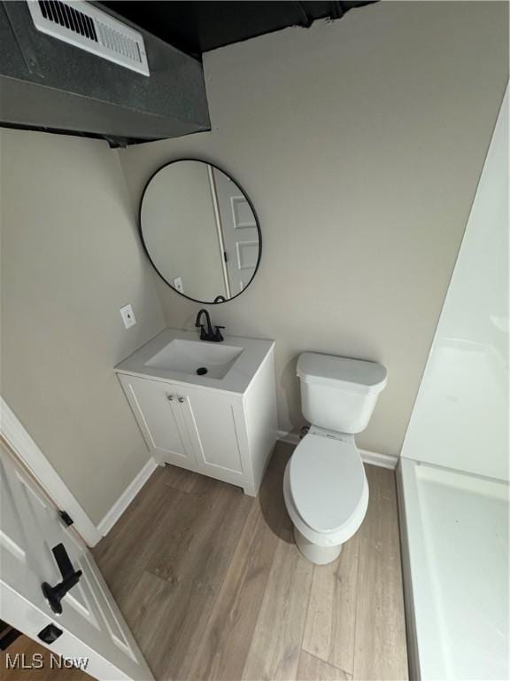 4827 E 88th St, Garfield Heights, OH 44125 - bathroom featuring wood finished floors, toilet, vanity, and baseboards