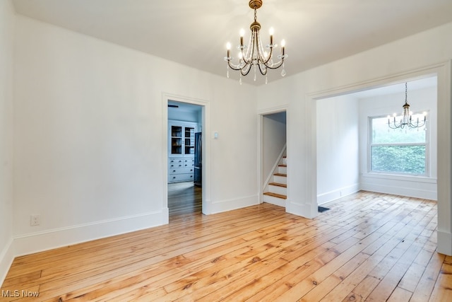 235 Elm St, Oberlin, OH 44074 - spare room featuring a chandelier, light wood finished floors, stairway, and baseboards