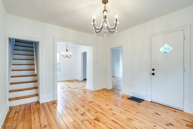 235 Elm St, Oberlin, OH 44074 - entrance foyer featuring a chandelier, stairs, light wood-style flooring, and healthy amount of natural light