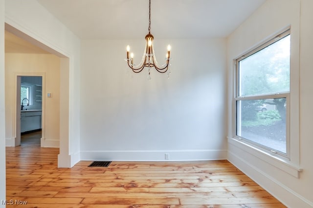 235 Elm St, Oberlin, OH 44074 - unfurnished dining area featuring a chandelier, light wood-style floors, baseboards, and a sink