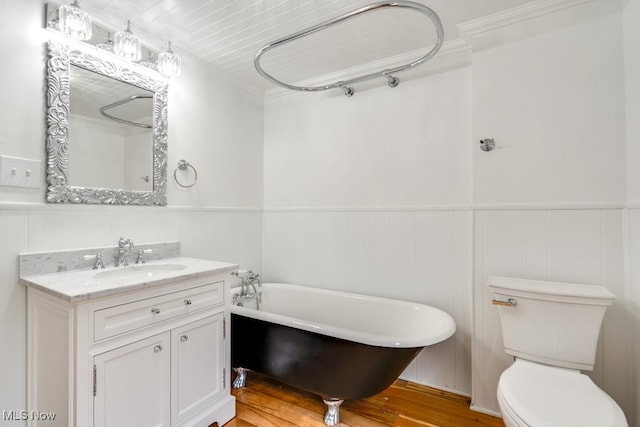 235 Elm St, Oberlin, OH 44074 - full bathroom with a soaking tub, vanity, a wainscoted wall, wood finished floors, and toilet