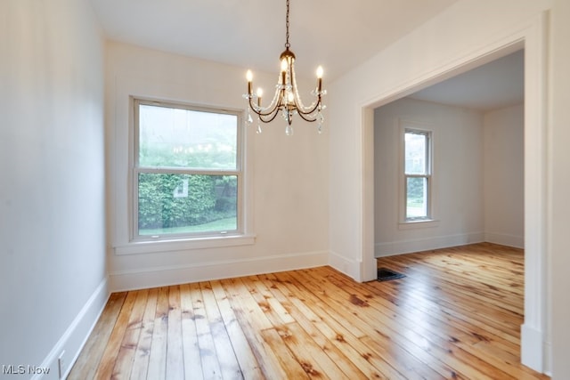 235 Elm St, Oberlin, OH 44074 - spare room featuring a chandelier, healthy amount of natural light, hardwood / wood-style flooring, and baseboards