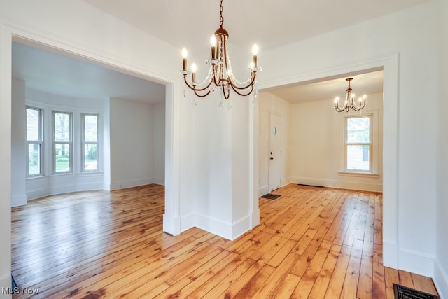235 Elm St, Oberlin, OH 44074 - unfurnished room with a chandelier, light wood finished floors, healthy amount of natural light, and baseboards