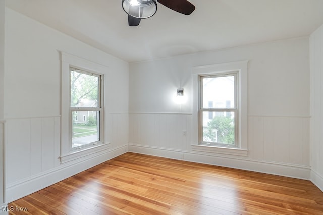 235 Elm St, Oberlin, OH 44074 - unfurnished room featuring wainscoting, light wood-style flooring, and ceiling fan