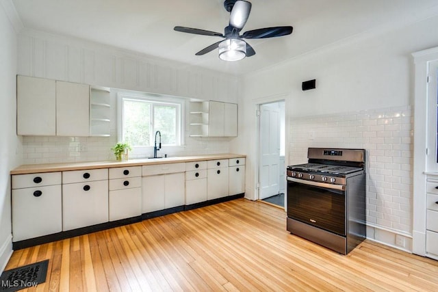 235 Elm St, Oberlin, OH 44074 - kitchen with gas stove, open shelves, decorative backsplash, light countertops, and light wood-style floors
