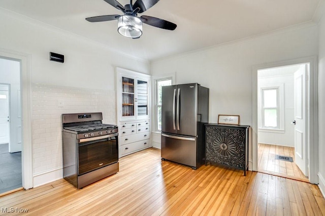 235 Elm St, Oberlin, OH 44074 - kitchen featuring stainless steel appliances, light wood finished floors, ornamental molding, ceiling fan, and tasteful backsplash