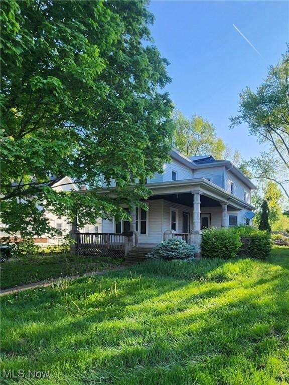 168 Whittlesey Ave, Norwalk, OH 44857 - back of house featuring a porch and a lawn