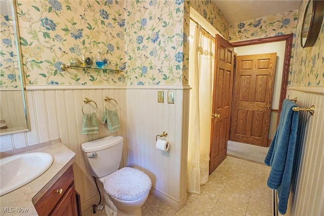 875 N Medina Line Rd, Akron, OH 44333 - bathroom with wallpapered walls, wainscoting, vanity, toilet, and tile patterned floors