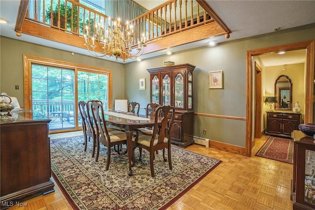 875 N Medina Line Rd, Akron, OH 44333 - dining room featuring a baseboard heating unit, baseboards, a chandelier, and a towering ceiling