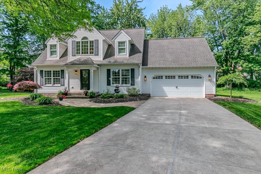 6504 Dawson Blvd, Mentor, OH 44060 - cape cod-style house with an attached garage, driveway, a front yard, and roof with shingles