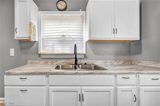 10234 Park Heights Rd, Cleveland, OH 44104 - kitchen featuring a sink, white cabinetry, and light countertops