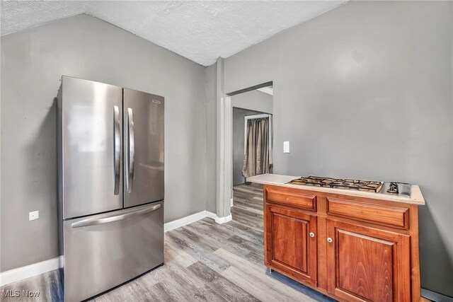 10234 Park Heights Rd, Cleveland, OH 44104 - kitchen with stainless steel appliances, a textured ceiling, light wood finished floors, baseboards, and light countertops