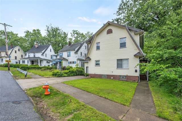 10234 Park Heights Rd, Cleveland, OH 44104 - view of front facade with a residential view, a front lawn, and a gambrel roof
