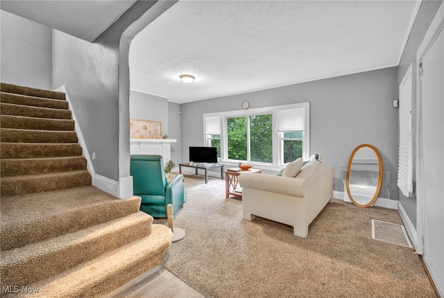 10234 Park Heights Rd, Cleveland, OH 44104 - living room with stairway, a brick fireplace, baseboards, and a textured ceiling