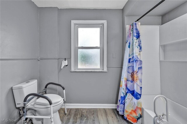 10234 Park Heights Rd, Cleveland, OH 44104 - bathroom with shower / tub combo with curtain, wood finished floors, baseboards, and toilet