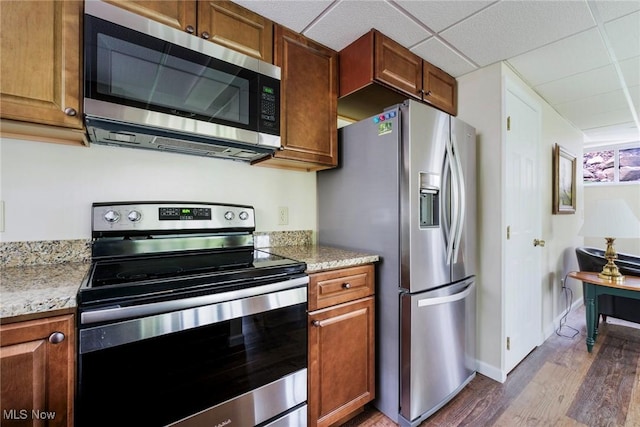 32094 Woodale Dr, Hanoverton, OH 44423 - kitchen featuring appliances with stainless steel finishes, dark wood finished floors, brown cabinets, a drop ceiling, and light stone counters