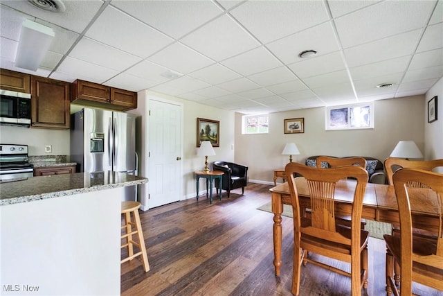 32094 Woodale Dr, Hanoverton, OH 44423 - dining space with dark wood finished floors, a drop ceiling, healthy amount of natural light, and baseboards