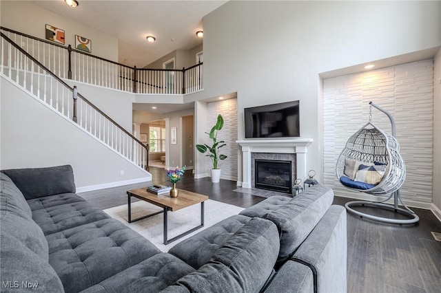443 S Hametown Rd, Copley, OH 44321 - living room featuring stairs, wood finished floors, baseboards, a towering ceiling, and a fireplace