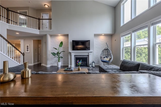 443 S Hametown Rd, Copley, OH 44321 - living area with a towering ceiling, stairs, a glass covered fireplace, and baseboards