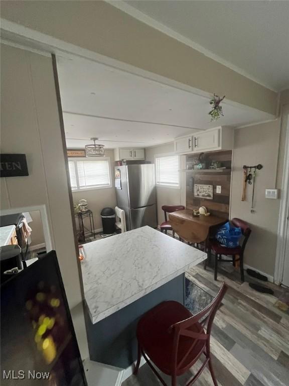 107 Marilyn Dr, Madison, OH 44057 - kitchen featuring freestanding refrigerator, white cabinetry, wood finished floors, and light countertops