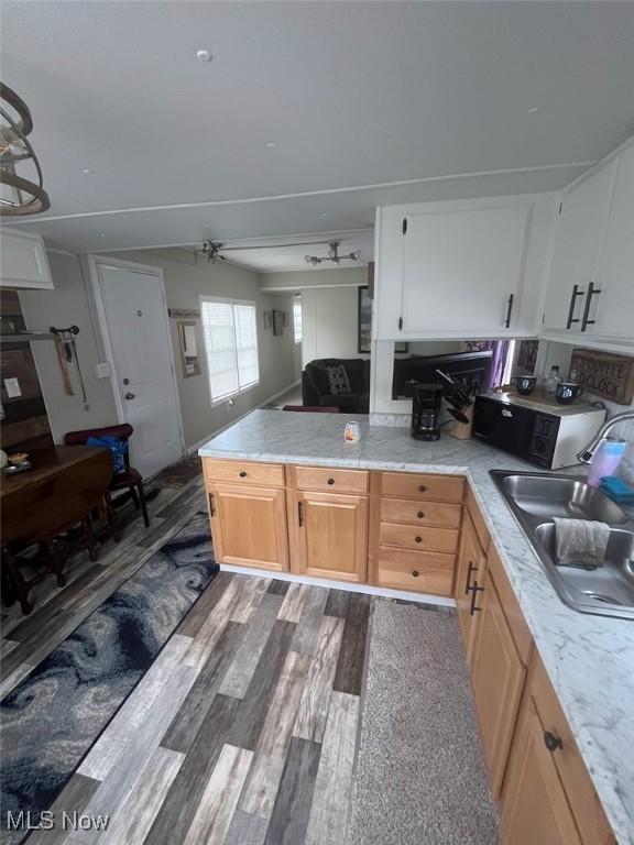 107 Marilyn Dr, Madison, OH 44057 - kitchen featuring a sink, light countertops, a peninsula, and dark wood-style floors