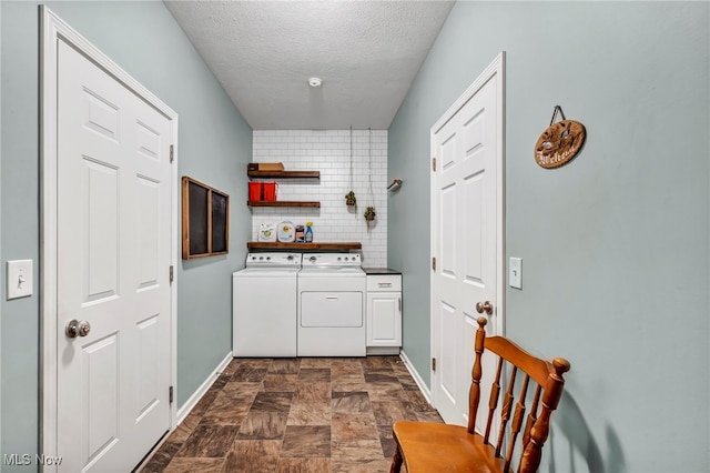 713 Westpointe Dr, Amherst, OH 44001 - laundry area with cabinet space, baseboards, stone finish floors, washer and clothes dryer, and a textured ceiling