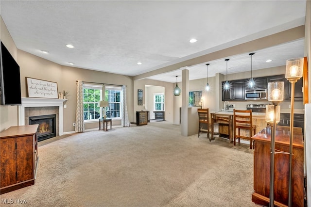 713 Westpointe Dr, Amherst, OH 44001 - living room featuring a fireplace, light colored carpet, recessed lighting, and baseboards