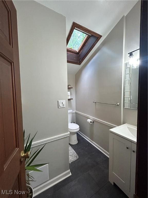 16112 Raymond St, Maple Heights, OH 44137 - bathroom featuring a skylight, vanity, toilet, and baseboards