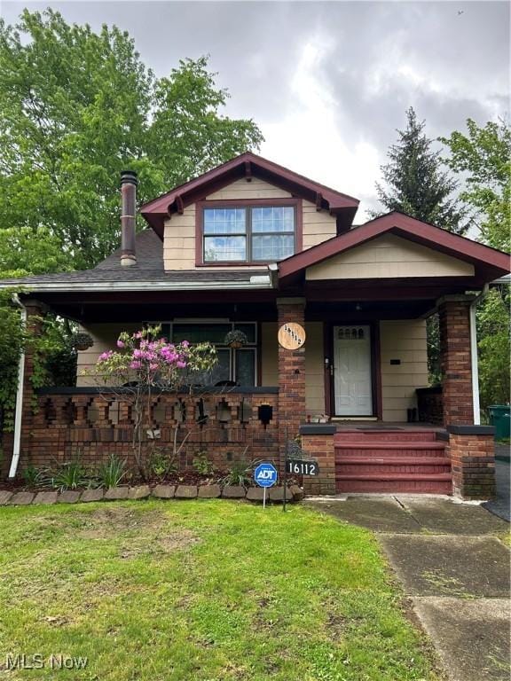 16112 Raymond St, Maple Heights, OH 44137 - view of front of property featuring covered porch, a front yard, and brick siding