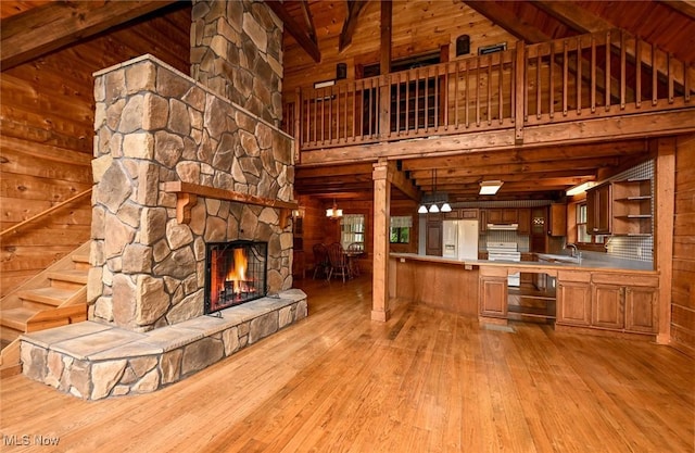 5360 Lance Rd, Medina, OH 44256 - unfurnished living room featuring light wood-type flooring, wooden walls, a fireplace, high vaulted ceiling, and wood ceiling with exposed beams