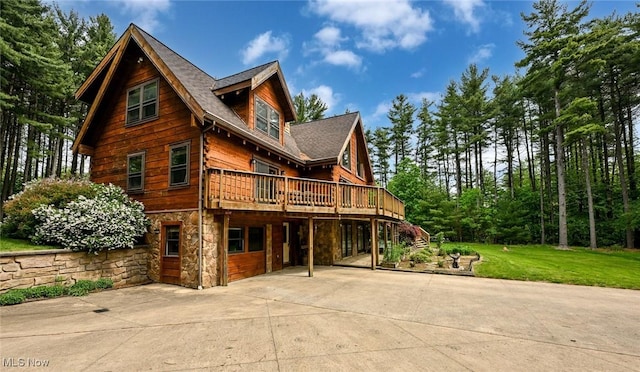 5360 Lance Rd, Medina, OH 44256 - rear view of house featuring stone siding, a deck, a shingled roof, and a yard